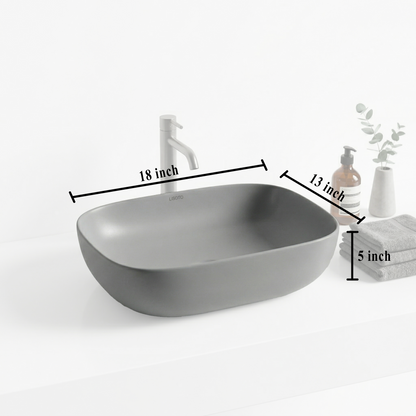 Gray matte table top basin and bathroom accessories on a countertop